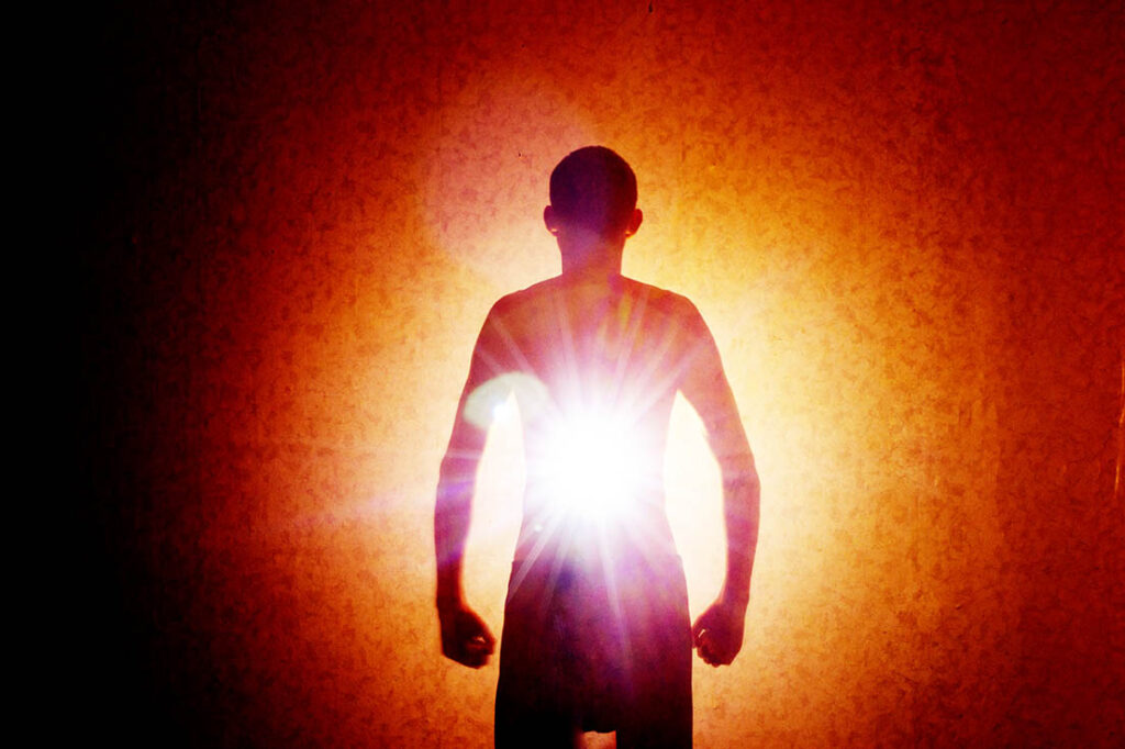 The outline of a man in the darkness with rays of light